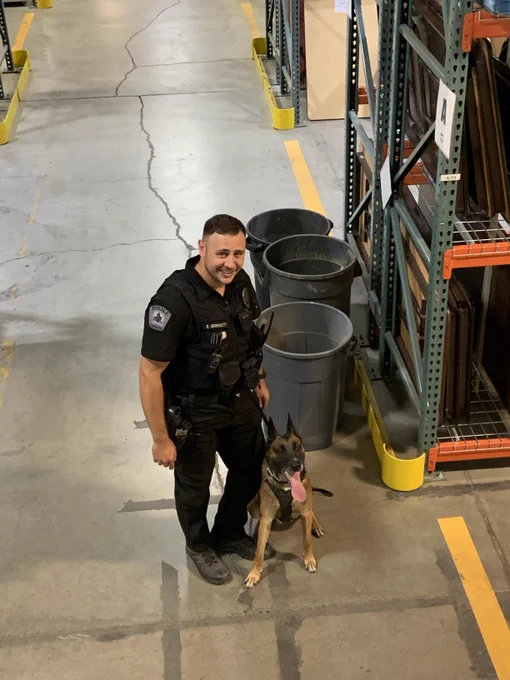 Police officer and his K-9 partner inside the DES Surplus building during a training.