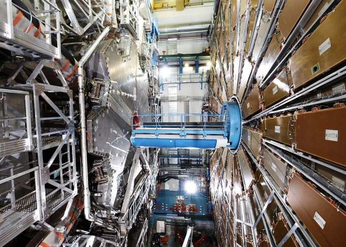 The inside of the ATLAS detector at the Large Hadron Collider at CERN. It has two huge flower-shaped metal devices connected by a metal column in the middle. 