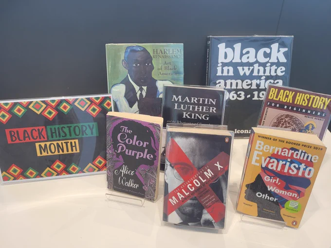 A book display for Black History Month at Riverside Library. There is a selection on books placed on stands upon a white table.