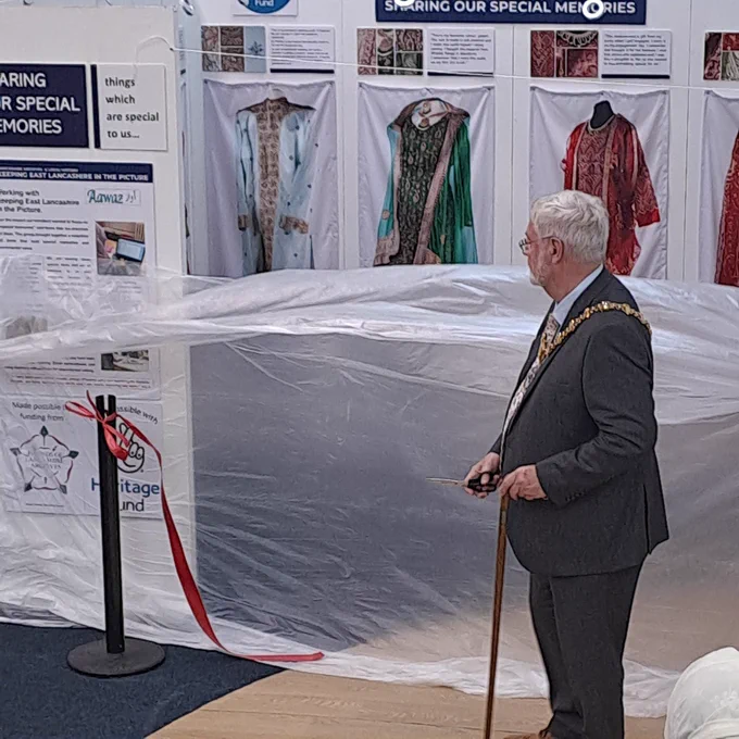 Mayor holding scissors after cutting the ribbon to open the new exhibition at Accrington Library 