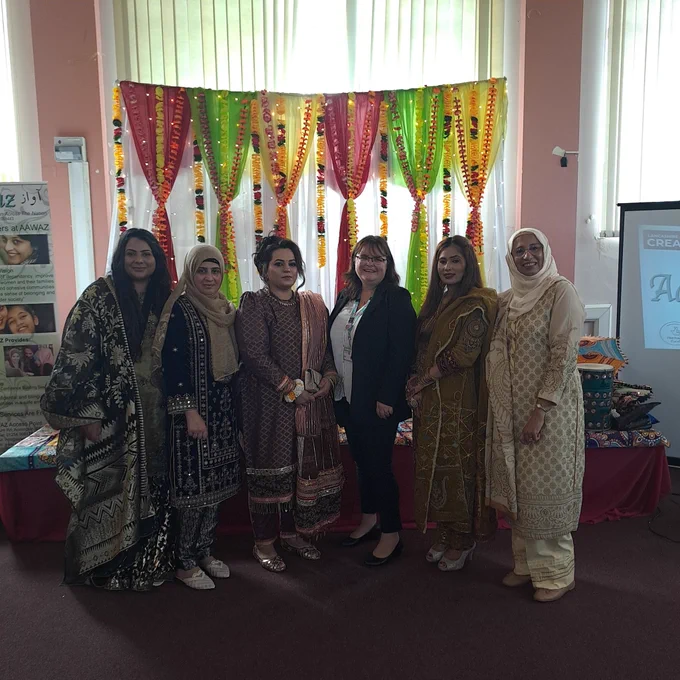 The ladies from Aawaz who were involved with the digitisation project standing in front of the decorated stage. A member of the Keeping East Lancashire In The Picture project is in the centre 