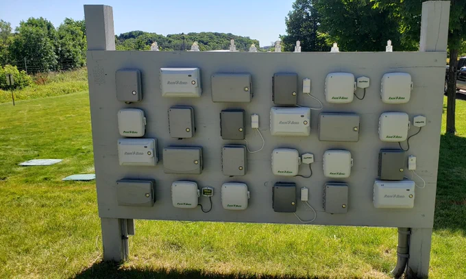 A panel with various irrigation controllers outside a turfgrass research area. 