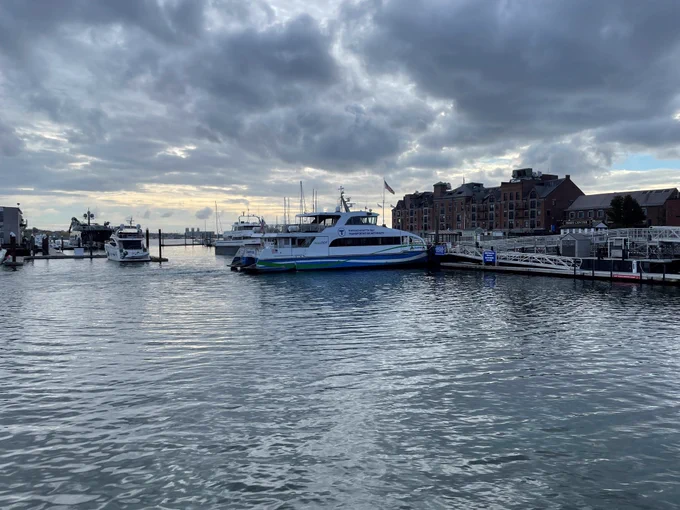 A Massachusetts Bay Transportation Authority ferry docked at a marina with old building in the background.