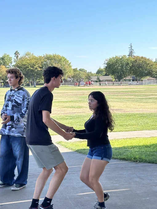 Students are gathered in pairs of two to practice a dance routine for Lincoln Latin Leadership