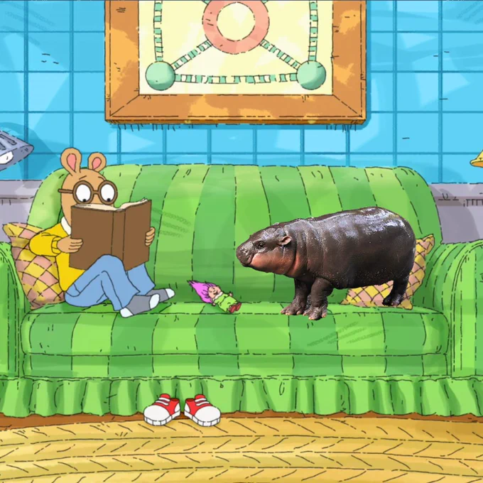 Arthur and Moo Deng sit on the couch together.