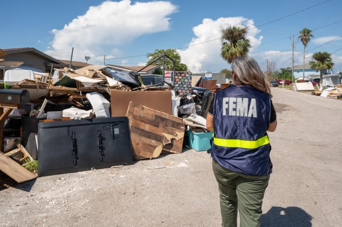 FEMA staff member walking by storm damages