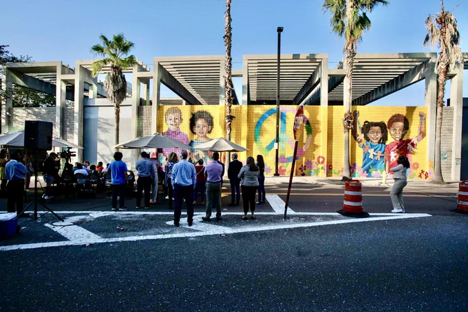 A crowd watched the mural unveiling ceremony