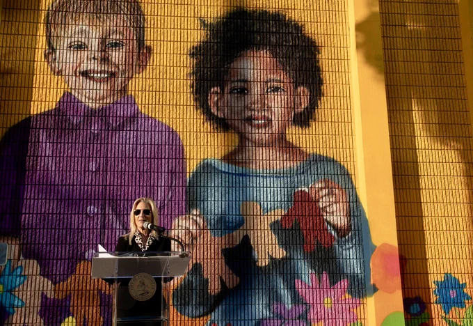 Mayor Deegan speaks in front of a mural of children