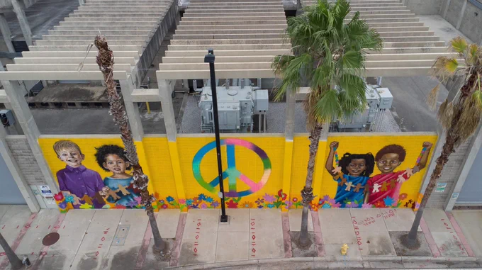 Aerial view of a mural with children and a peace sign.