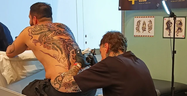 Tatuatore che sta facendo un tatuaggio sulla schiena di un uomo - Tattoo Convention