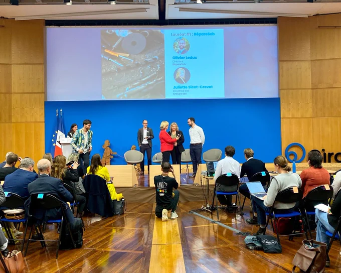 Sur scène, Marie-Agnès Poussier-Winsback remet aux lauréats le Trophée des Alliances circulaire.