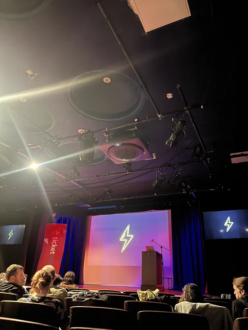 Inside the theatre, the stage is set for the conference with a ticketsolve pull up and podium.