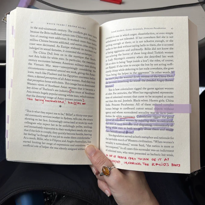 Photo of a book opened on a page with sentences highlighted and comments written in red ink