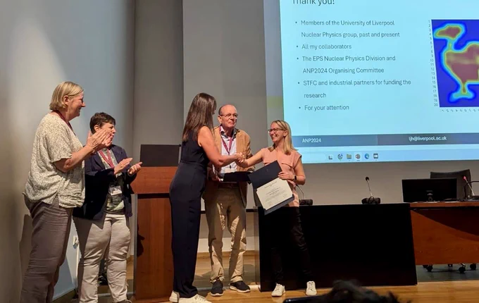 Laura is receiving the EPS Nuclear Physics Division Prize for Applied Nuclear Physics at the Applied Nuclear Physics International Conference in Thessaloniki, Greece. She is pictured here on stage receiving a round of applause while shaking hands with the woman giving her the prize.