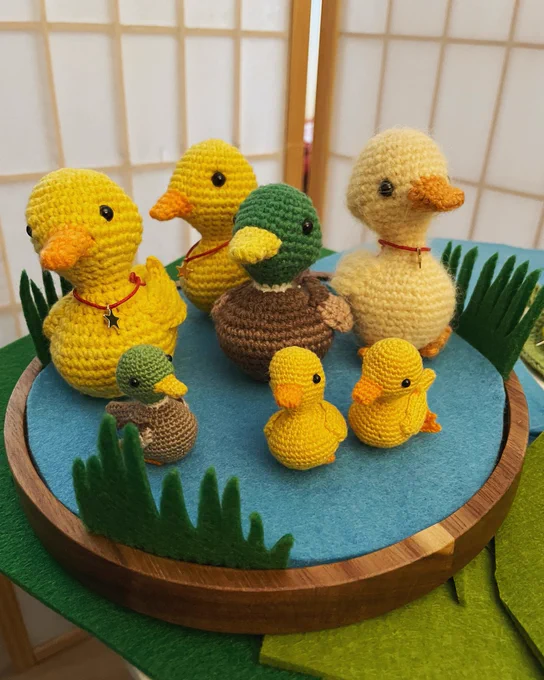 Crochet ducks sitting on a felt pond.