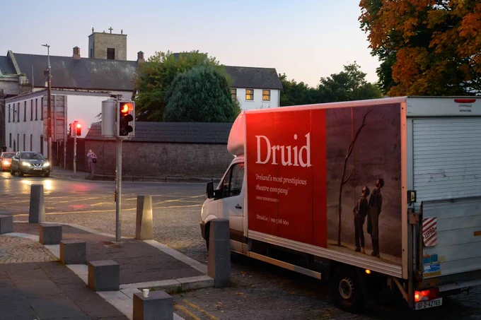 The Druid van stopped at a red traffic light at dusk in Galway city