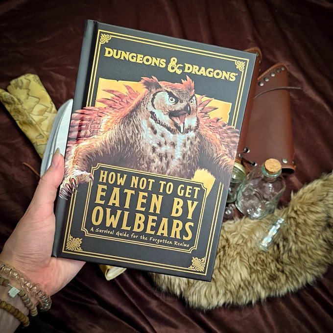A picture of Dungeons & Dragons How Not To Get Eaten by Owlbears with some themed fantasy bits in the background including; Fur, bottles, arm guards and a map.