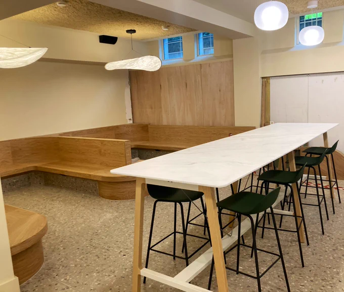 Another seating area in the Pumphandle Social space, with a mix of high stools and low seating.