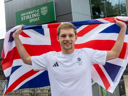 Duncan Scott poses with a Union Flag in front of the University of Stirling Sports Centre.