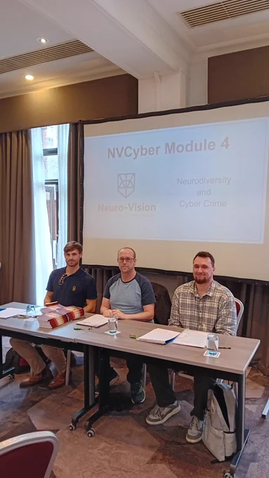 Callum, Geoff and Ashley sat side by side with the presentation slides in the background for Creased Puddle's NCA training.