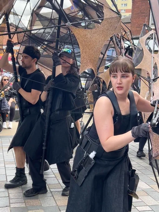 Hannah puppeteering the dragon’s arm with puppeteers in the background.