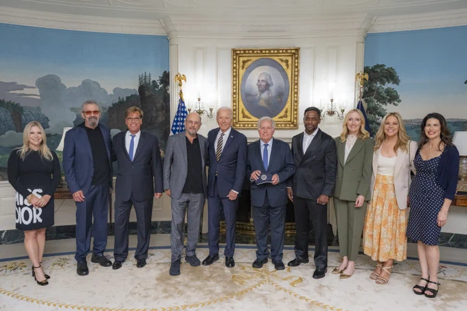 President Biden takes a photo with West Wing cast members.