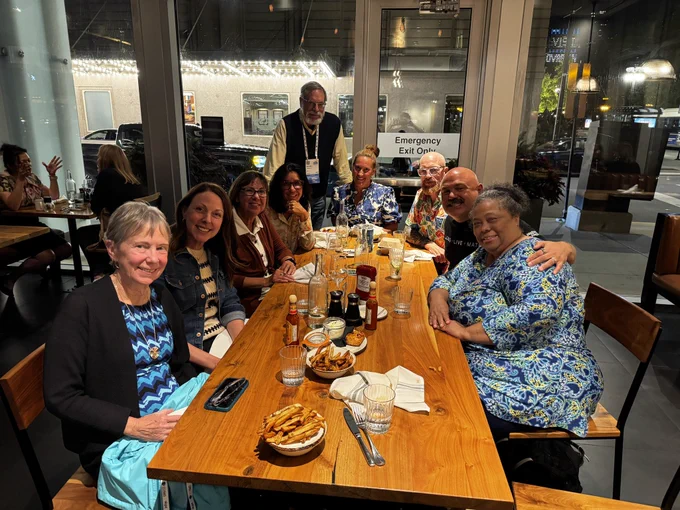 A group photo of conference attendees having dinner