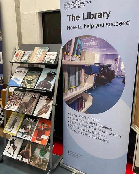 A display of books and journals next to a banner promoting the Library at the Welcome Fair at Aldgate Campus.