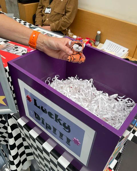 A soft toy tiger being taken out of the Lucky Dip box at the Welcome Fair at Aldgate Campus.