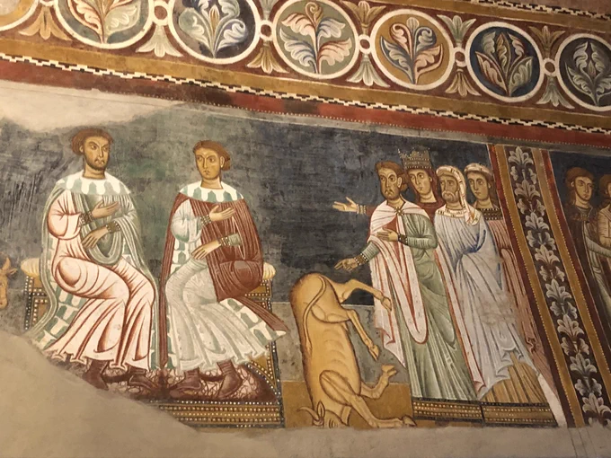 Fresco at Oratorio di San Silvestro, Rome, showing a scene from the Silvester legend: his disputation with Jews brought along by Helena and presided over by 2 pagan judges, in the course of which one uses magic to kill a bull.