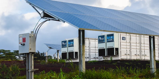 A PV array and a battery energy storage system in a grassy field