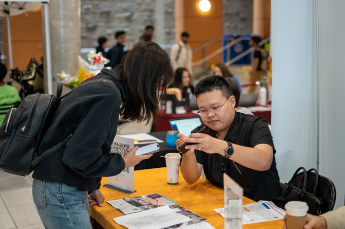 Student and representative looking at program details at the fair