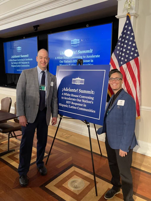A picture of HIV.gov’s Miguel Gomez and Building Healthy Online Communities’ Jen Hecht posing in front of a White House placard that reads: “Adelante Summit: A White House convening to accelerate our nation’s HIV response in Hispanic/Latino Communities.”