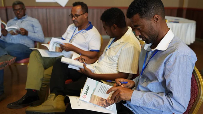 Four men seated reading SEADS handbook
© FAO Ethiopia