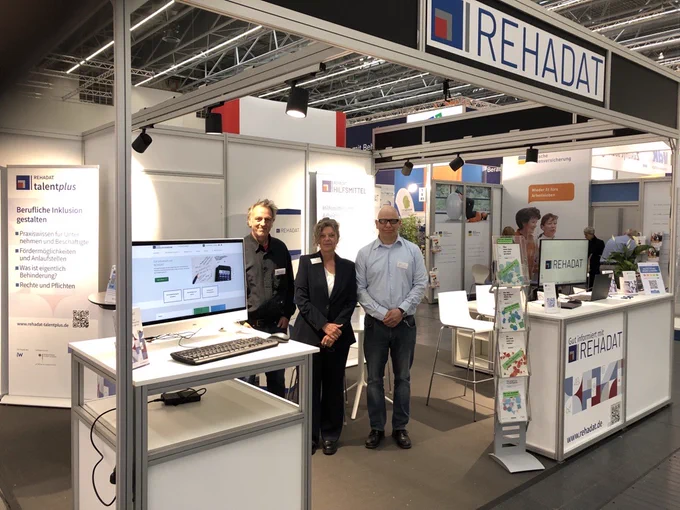 REHADAT-Stand auf der REHACARE 2024 mit den 3 REHADAT-Kollegen