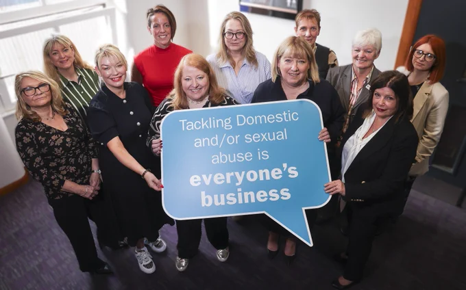 Justice Minister Naomi Long is pictured with stakeholders at the launch of the new Domestic & Sexual Abuse Strategy. The group is pictured holding a key message from the strategy 'tackling domestic and or sexual abuse is everyone's business'