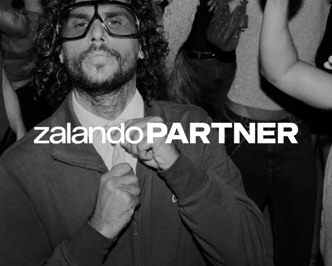 zalando Partner - a black and white photo of a man with large glasses, adjusting his tie