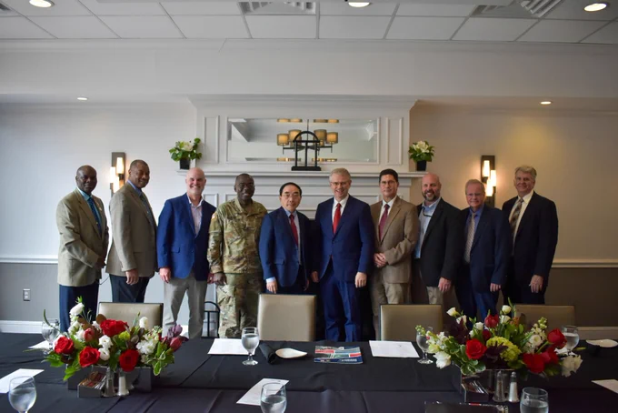 A group of officials from ERDC and colleagues from UGA IRIS pose before a lunch table.