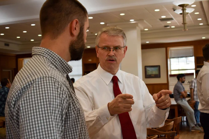 Dr. David Pittman points to a poster during conversation with UGA IRIS research engineer Will Mattison.