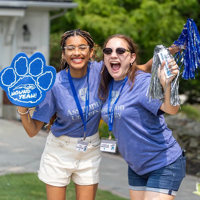 Two students smile for a picture wearing their Assumption University swag.