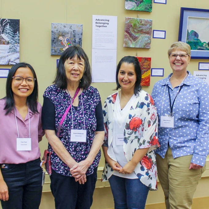 Artists smiling in front of their work.