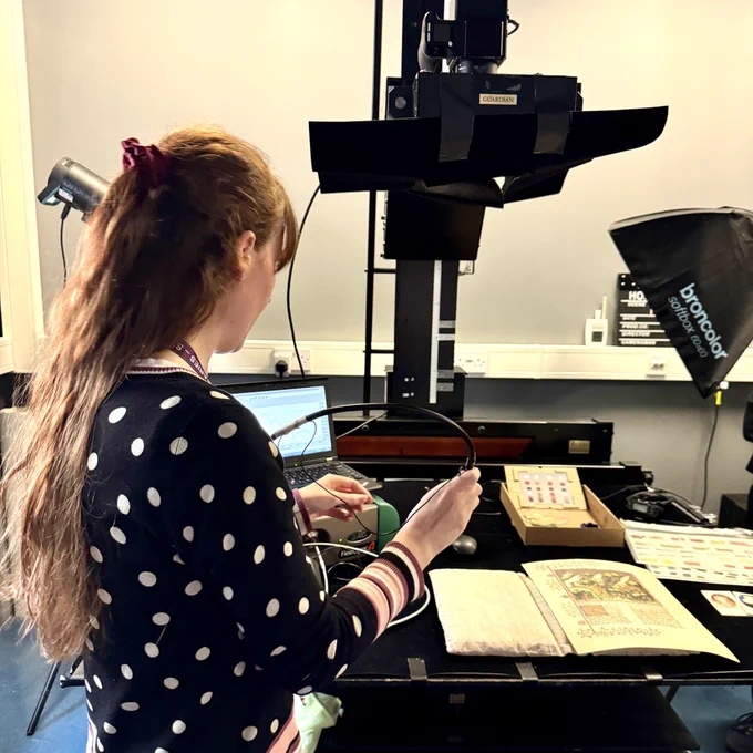 A team member from Cambridge University Library's Cultural Heritage Imaging Laboratory, using the latest technology to examine a manuscript in the lab.