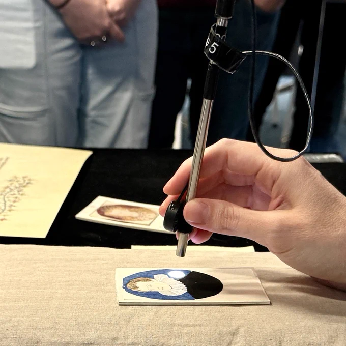 A team member from Cambridge University Library's Cultural Heritage Imaging Laboratory, using Fiber Optic Reflectance Spectroscopy (FORS) to examine an image.