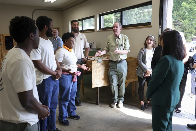 Acting Secretary Julie Su speaks with several Job Corps students and instructors inside a workshop.