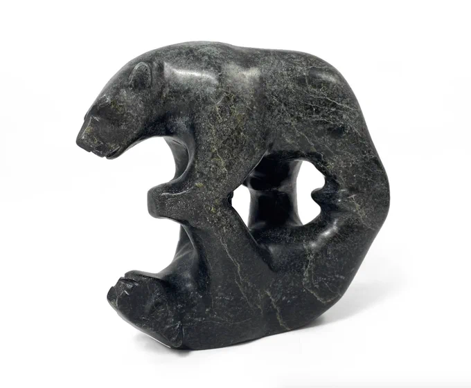 A carved polar bear walking on all fours, with a mirrored upside-down reflection carved from the same piece of stone below.