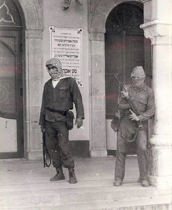 PLO in front of the Maghen Abraham Synagogue in Wadi Abu Jamil, a Jewish neighbourhood of Beirut, during the Civil War in Lebanon.

I've seen this dated to 29th December 1975. Though I'm unsure.