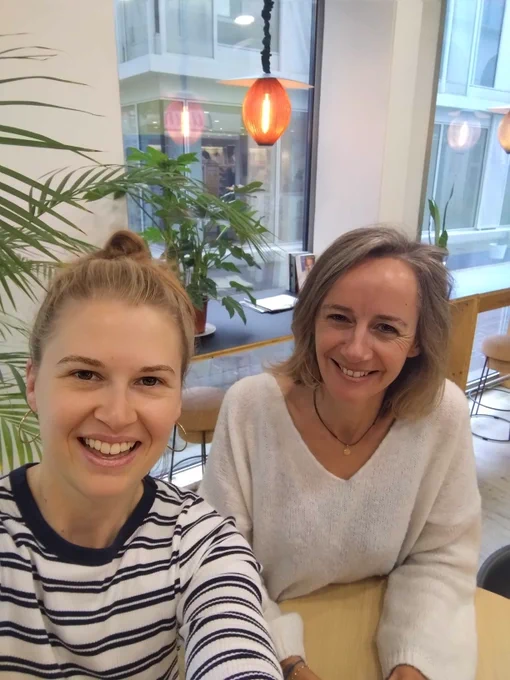 Deux personnes qui se prennent en selfie, souriantes.