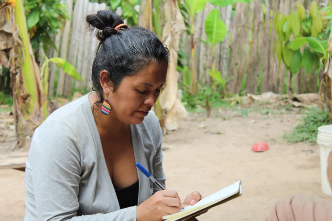 Dr Carol Zavaleta taking notes during fieldwork in Peru.