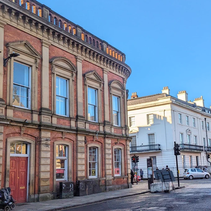 A gorgeous redbrick building with large windows on a street corner in York.