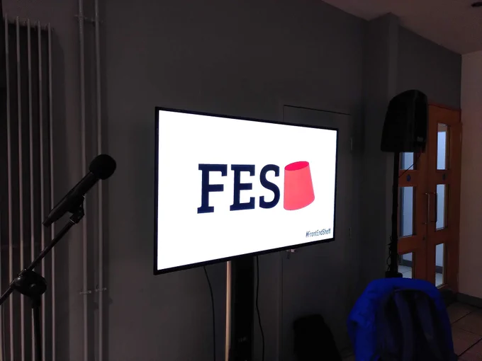 A large TV screen showing the FES logo